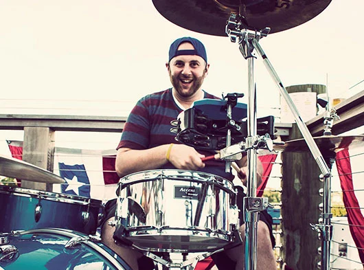 Joe Saad looking at camera head on playing drums at former Stony Creek Brewery in Branford, CT
